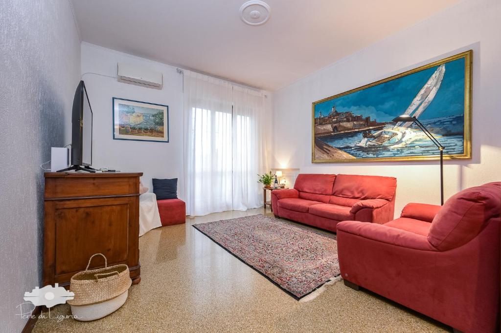 a living room with two red couches and a television at La casa del marinaio in Genova
