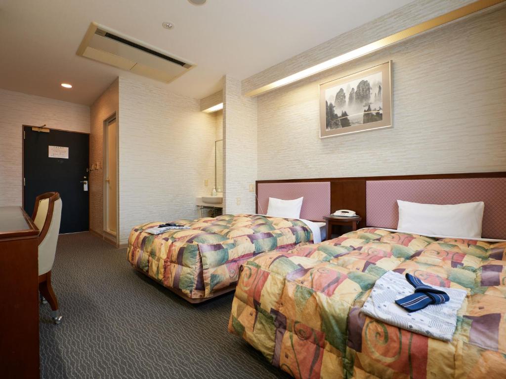 Postel nebo postele na pokoji v ubytování Gamagori Hotel