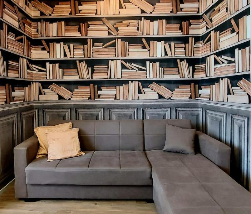 een bank in een kamer met een muur van boeken bij Sui Canali in Livorno