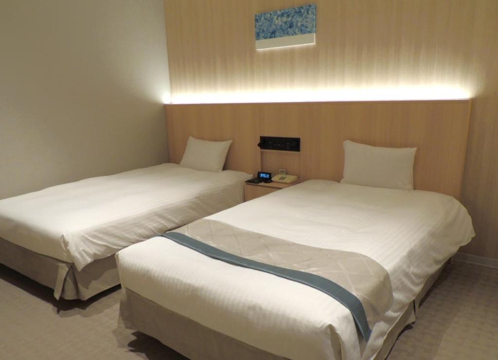 2 camas en una habitación de hotel con en Grand Xiv naruto the lodge en Naruto