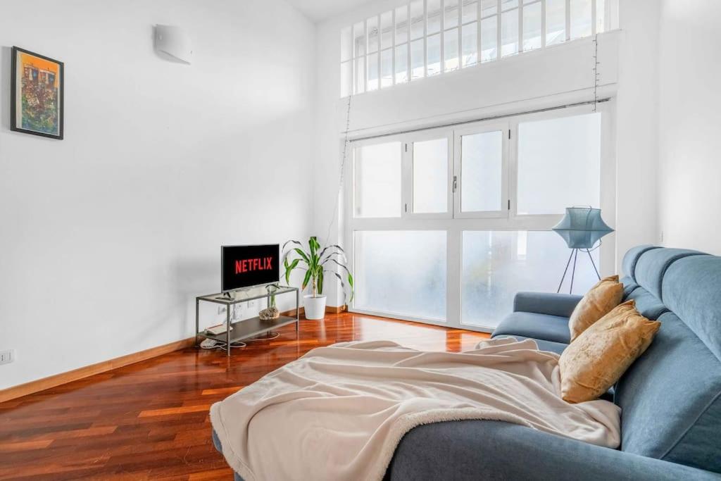 a living room with a blue couch and a tv at -Ethnic Design Loft- con soppalco [Città Studi M2] in Milan