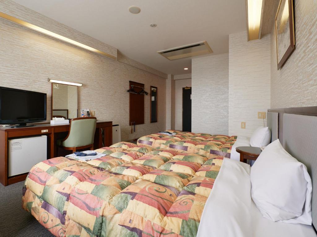 Postel nebo postele na pokoji v ubytování Gamagori Hotel