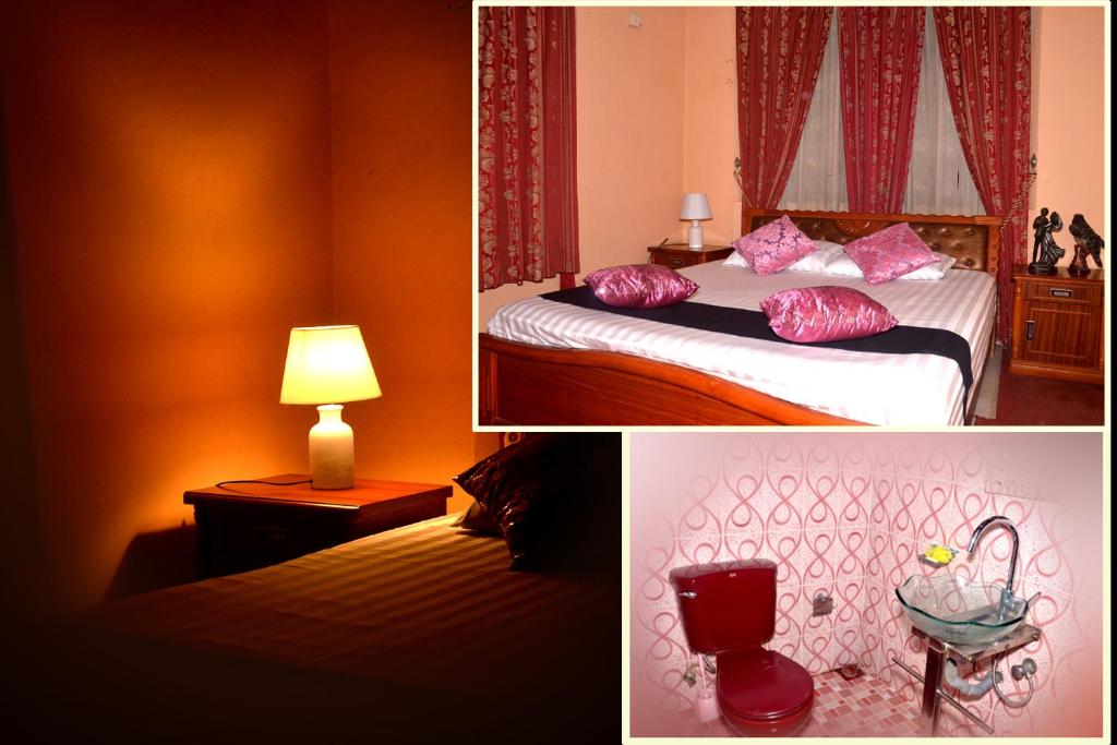 a hotel room with a bed with pink pillows at The Kings Villa. in Wattala