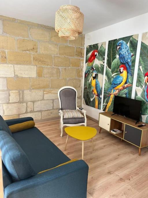 - un salon avec un canapé bleu et des peintures murales dans l'établissement Maison de ville St Bruno, à Bordeaux