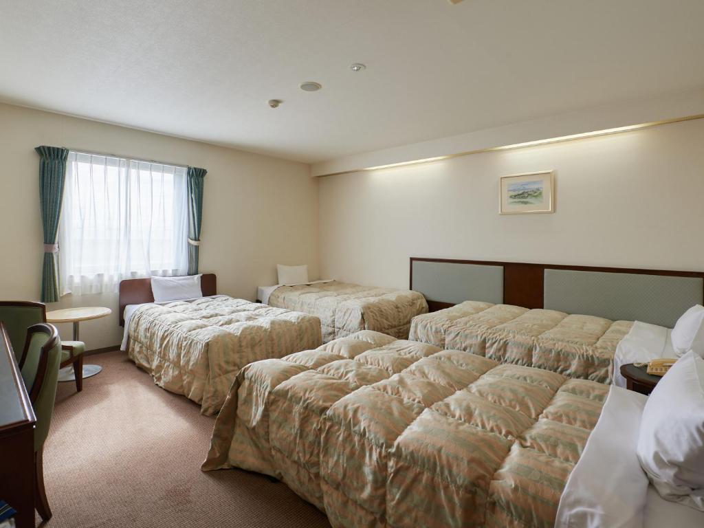 Postel nebo postele na pokoji v ubytování Gamagori Hotel