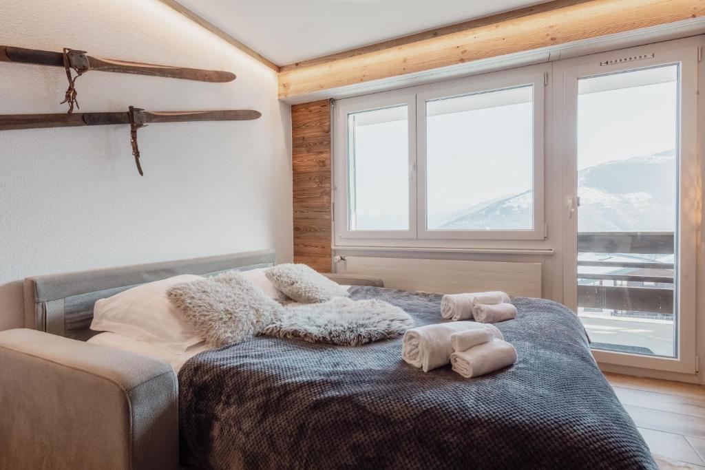 - une chambre avec un lit et 2 serviettes dans l'établissement Charmant studio avec une vue imprenable, à Nendaz
