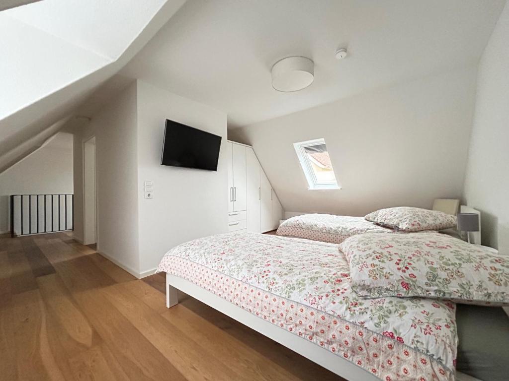 1 dormitorio con 2 camas y TV en la pared en La Casa Gialla, en Verden