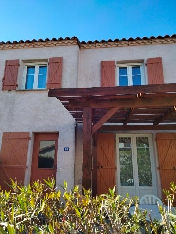 une maison avec des portes et des fenêtres rouges dans l'établissement IRIS, à Aigues-Mortes