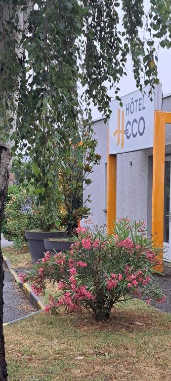 un cartello con scritto hoco e fiori di fronte a un edificio di Hotel HECO Lyon sud Vienne a Vienne