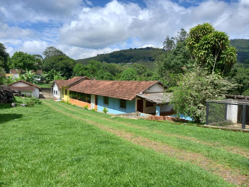 Sítio das Pedras في ماتياس باربوسا: منزل في حقل مع ساحة عشب