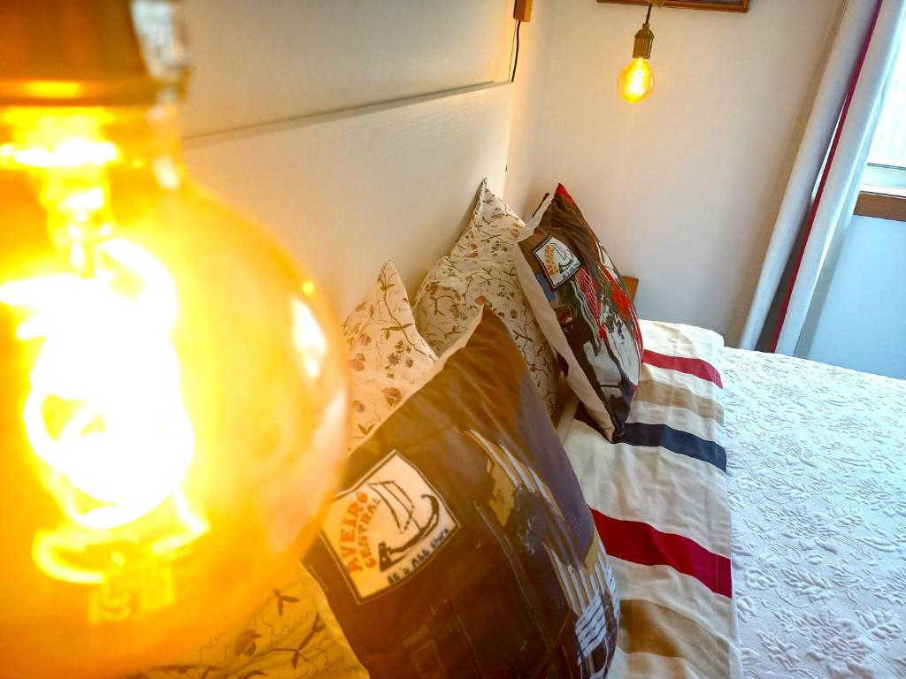 a lamp on top of a bed with a pillow at Aveiro Central - It´s ALL there in Aveiro