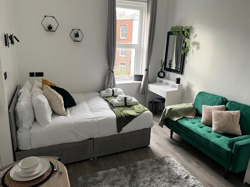 a bedroom with a bed and a green couch at Blue Sky Stays Preston in Preston