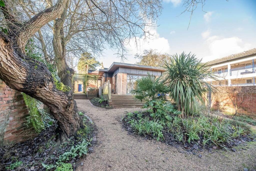 una casa con una pared de ladrillo y un árbol en 8 Bredfield Street, en Woodbridge