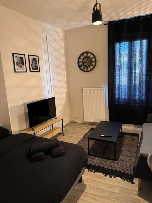 un salon avec un lit et une télévision dans l'établissement Black Studio, au Havre