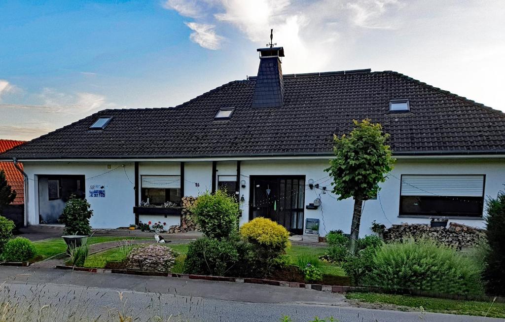 Biały dom z czarnym dachem w obiekcie Ferienwohnung Rosenpflanzer w mieście Bad Oeynhausen