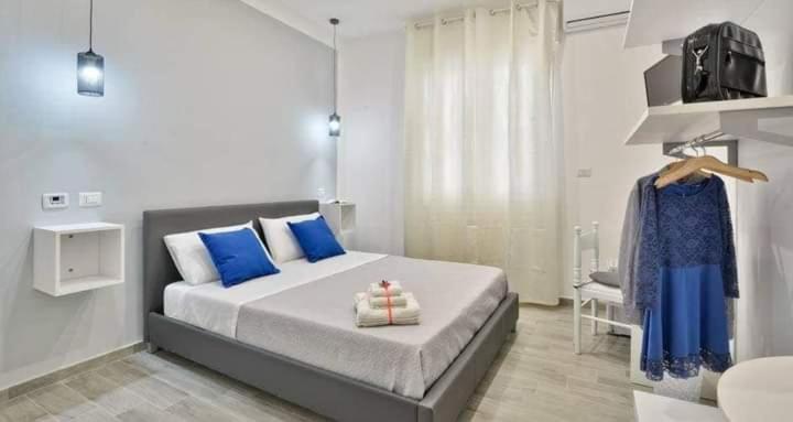 a bedroom with a large bed with blue pillows at B&B Iris in Santa Maria di Castellabate