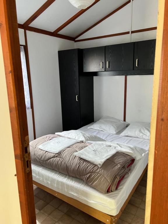 1 dormitorio con 2 camas y armarios negros en Chalet N13 en Saint-Julien-de-Peyrolas