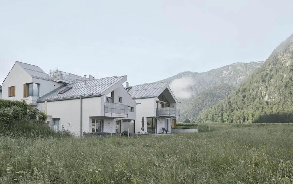 uma casa num campo com montanhas ao fundo em TIROLER TRIS Chalet & Penthouse em Maurach