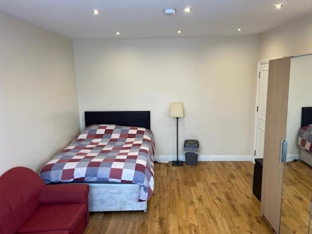 a bedroom with a bed and a couch at Spacious and Sunny double Room for comfortable nap in Harrow on the Hill