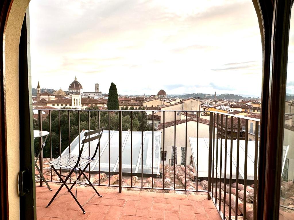 uma varanda com cadeiras e vista para a cidade em Palazzo Pandolfini's City-View Studios em Florença