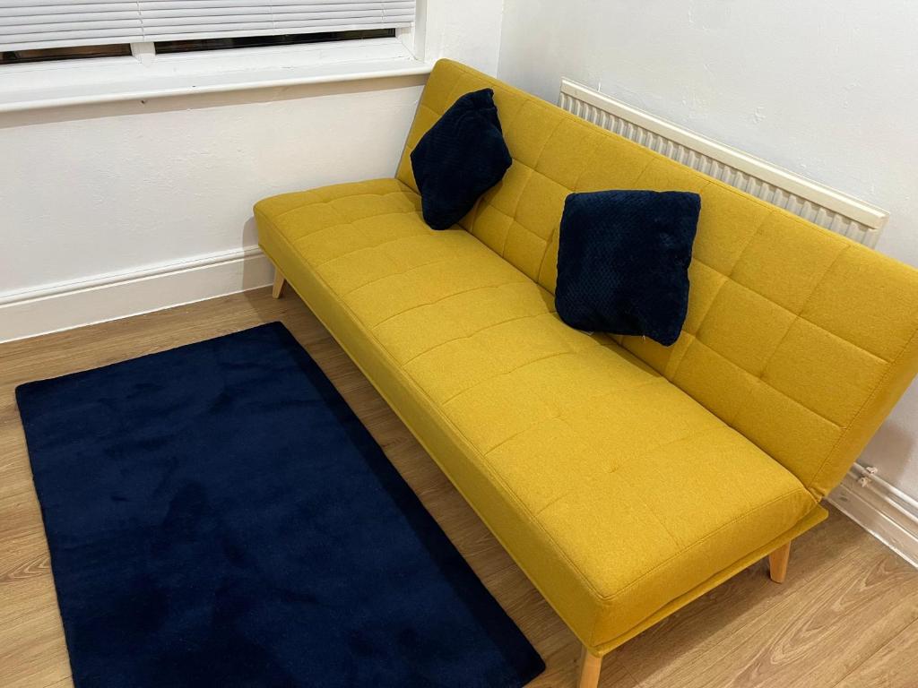 De Luxe apartment 1 في ليستر: أريكة صفراء في غرفة مع سجادة زرقاء