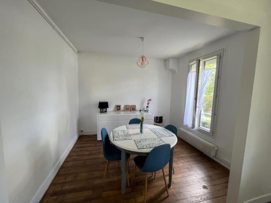uma sala de jantar com uma mesa e cadeiras azuis em Maison indépendante Chambly 3 chambres em Chambly