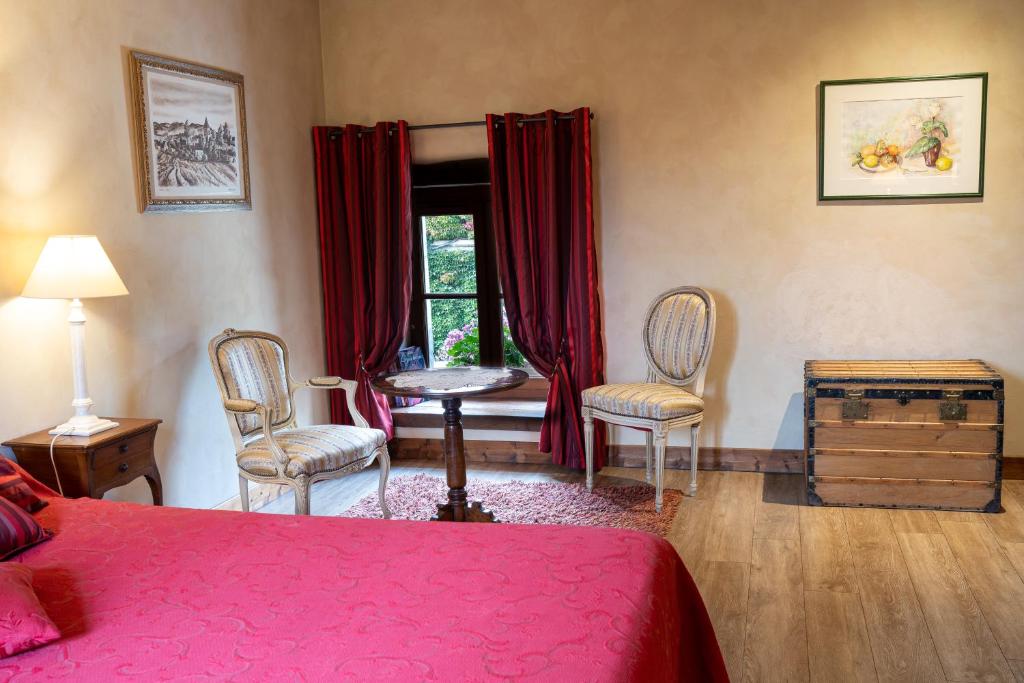 a bedroom with a bed and chairs and a window at Château de Ribourdin in Chevannes