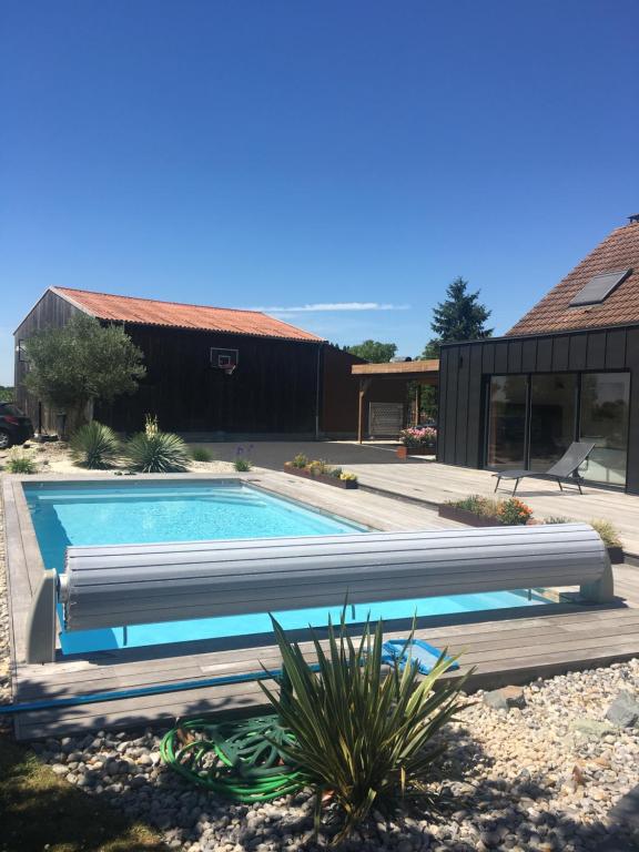 a swimming pool in front of a house at Maison 24H du Mans in Teloché