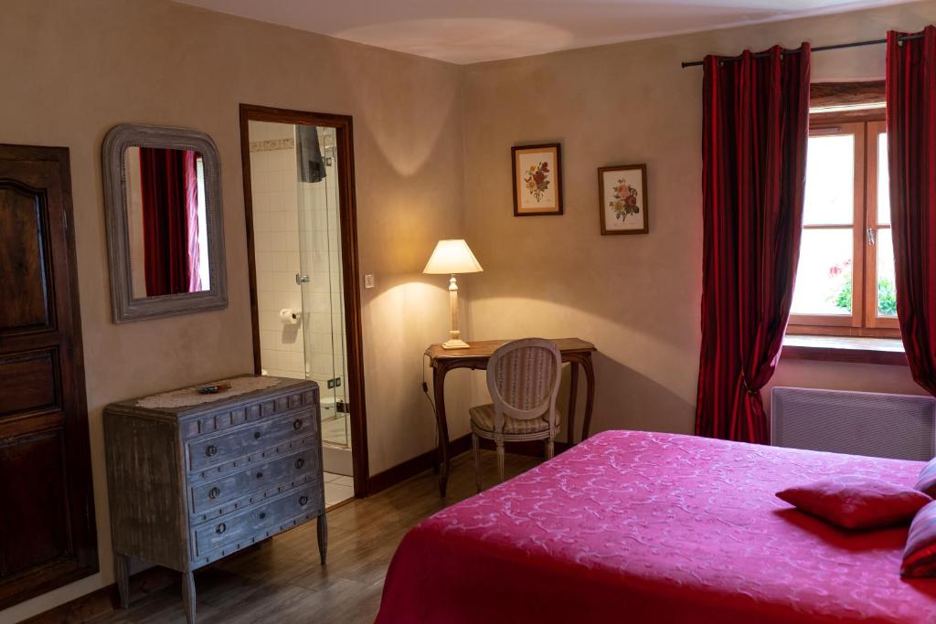 a bedroom with a bed and a desk and a window at Château de Ribourdin in Chevannes