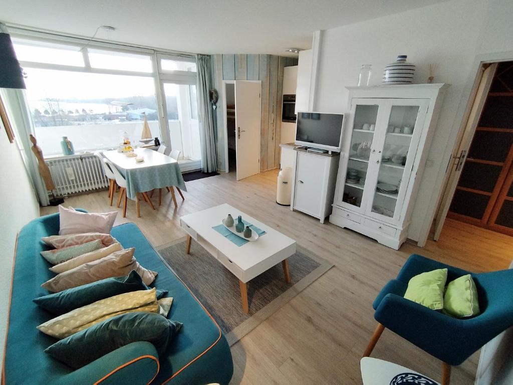 een woonkamer met een blauwe bank en een tafel bij Ferienpark M05-001 Ferienpark in Heiligenhafen