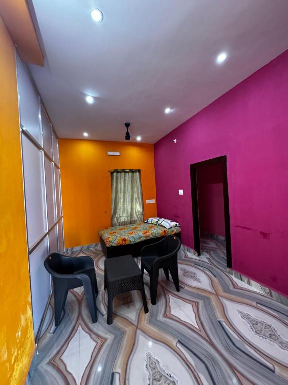 a room with colorful walls and a table and chairs at JP HOME STAY in Tiruvannāmalai
