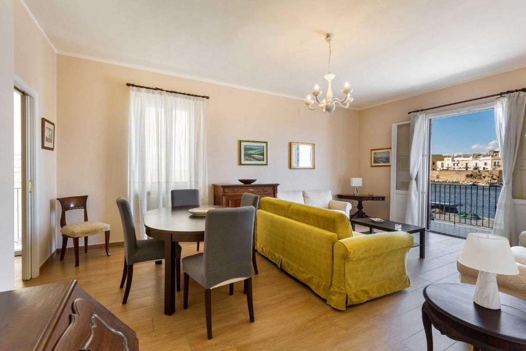a living room with a yellow couch and a table at Balconcino sul Rivellino by BarbarHouse in Gallipoli