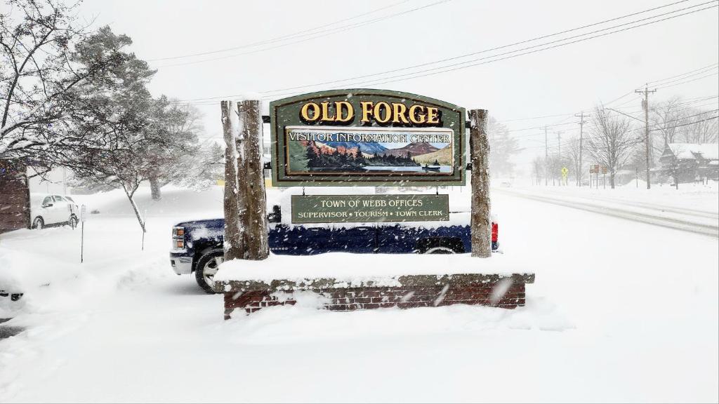 an old fence sign in the snow on a street at 4 BDRM - Hot Tub - Fire Pit in Old Forge