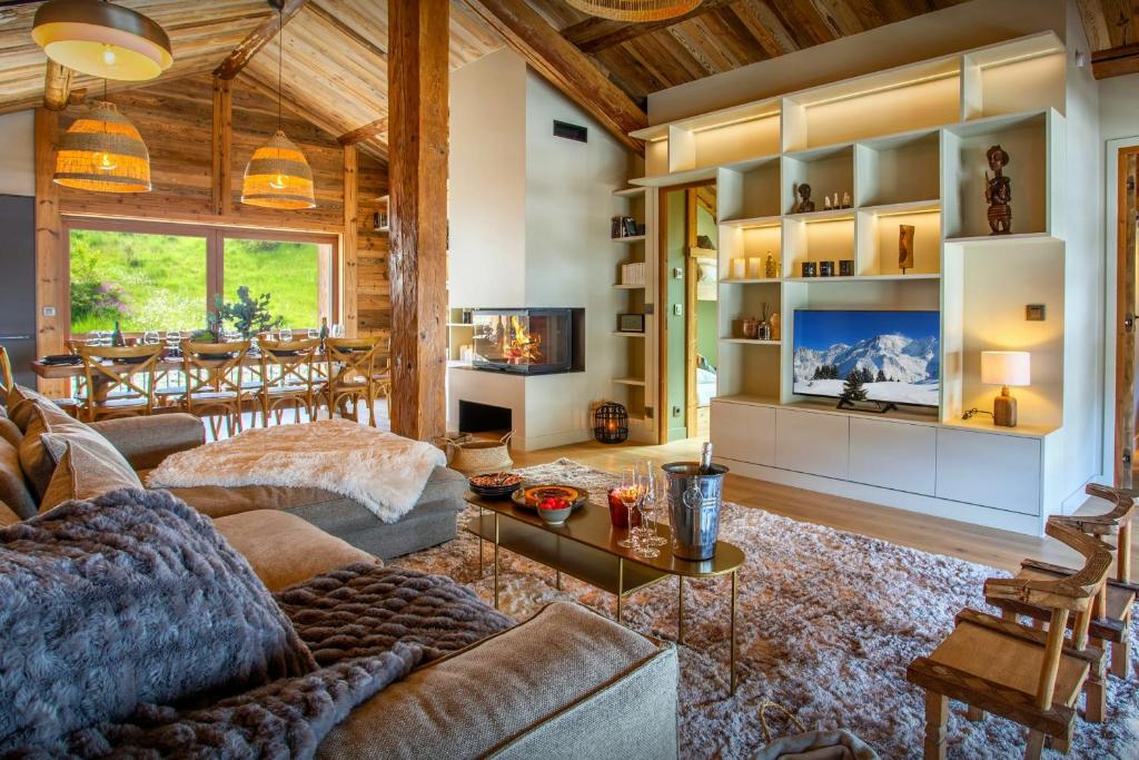 Una sala de estar con un sofá y un televisor. en Chalet Backflip - OVO Network, en La Clusaz