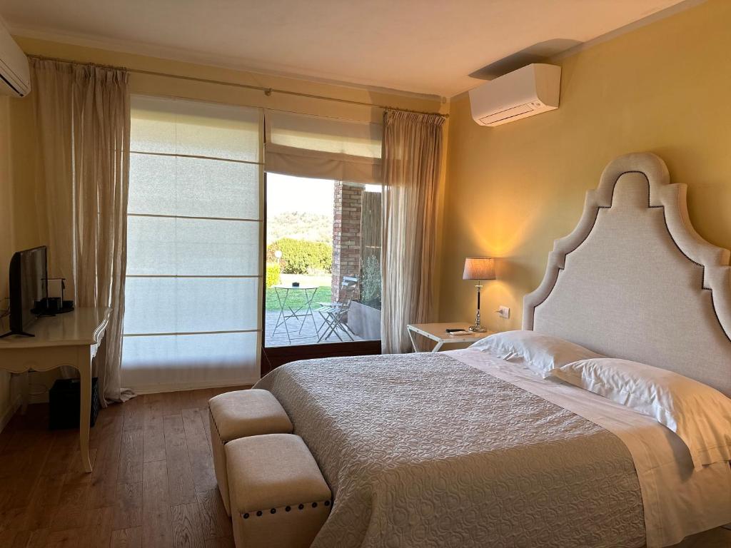 a bedroom with a large bed and a balcony at Saturnia Country Villas in Saturnia