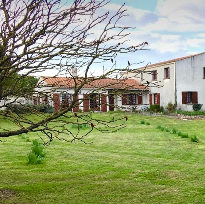 une maison avec une cour d'herbe devant un bâtiment dans l'établissement BORD DE MER, à Aytré