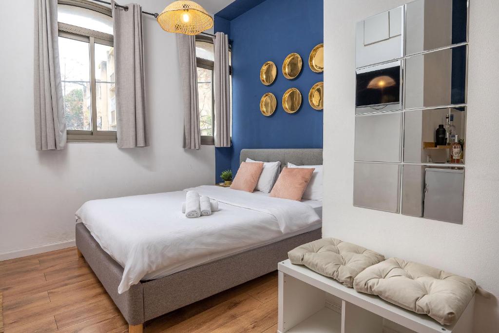 1 dormitorio con 1 cama con pared azul en GODSON TALPIOT, en Haifa