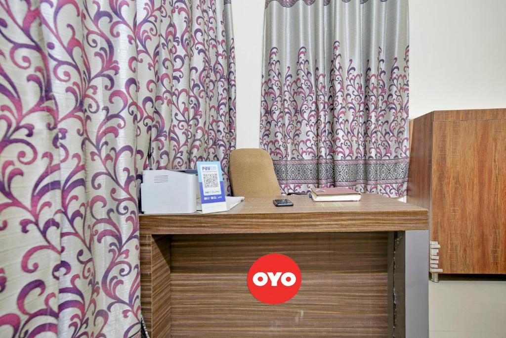 a desk in a room with a curtain at Wave Inn Guest House in Ludhiana