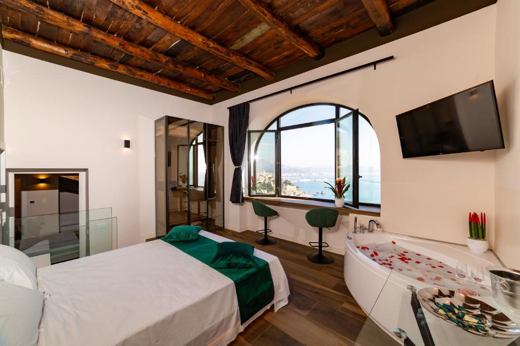 a bedroom with a bed and a large window at Kemì Luxury Suites in Vietri sul Mare