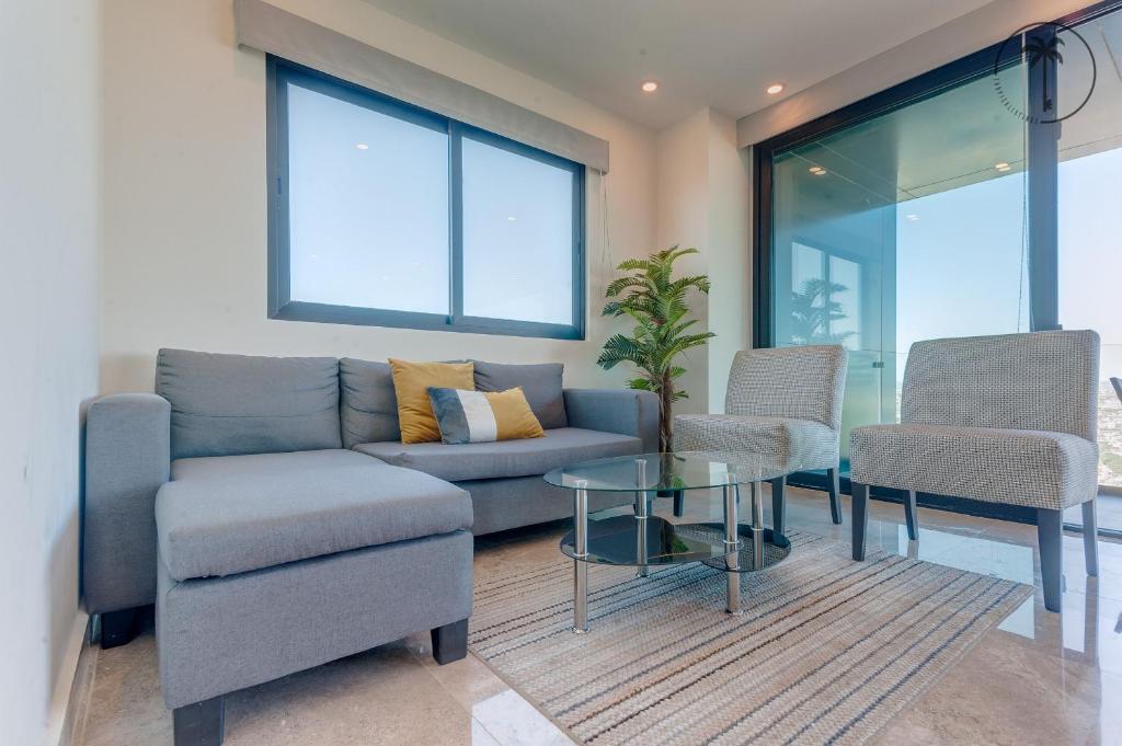a living room with a couch and two chairs and a table at Lujoso residencial con amenidades únicas in Mazatlán