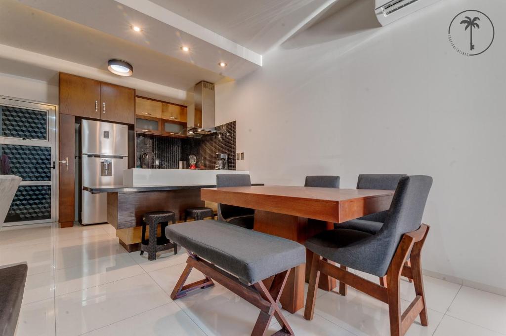 馬薩特蘭的住宿－ALFA - Dpto 2 hab en zona céntrica y cerca de la playa，厨房以及带木桌和椅子的用餐室。