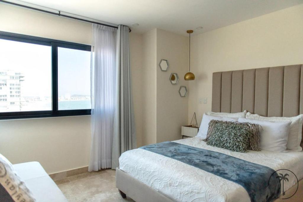 1 dormitorio con cama grande y ventana grande en Nuevo Departamento en el Malecón! en Mazatlán