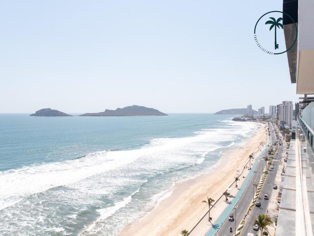a view of a beach with palm trees and the ocean at Hermosa Vista al Mar, Condominio de Lujo! in Mazatlán