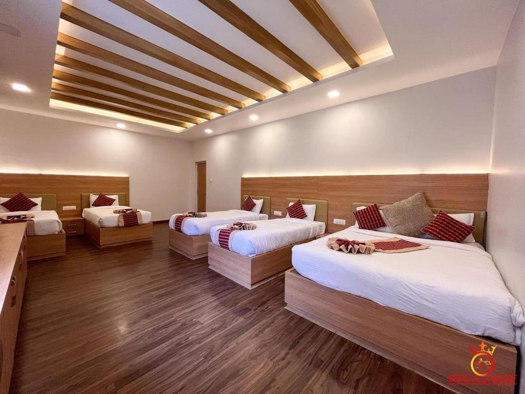 a room with three beds in it with wooden floors at ROYAL VILLA RESORT in Kathmandu
