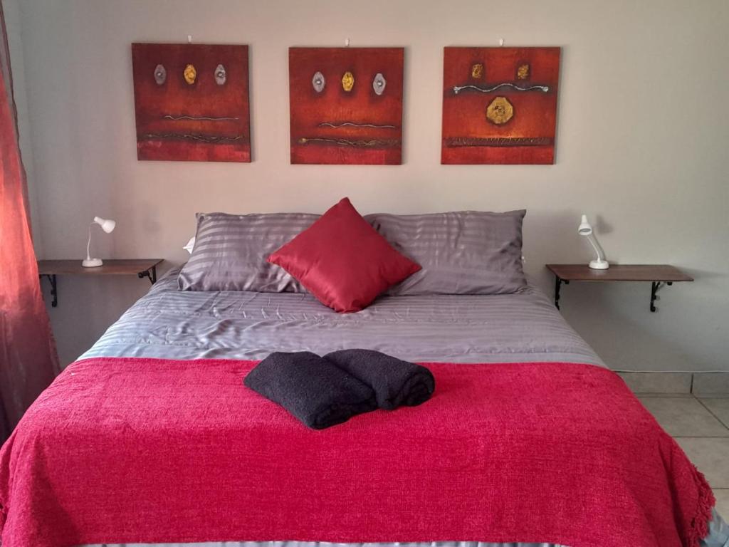 a bedroom with a bed with a red blanket at Sweet Dreams Polokwane in Polokwane