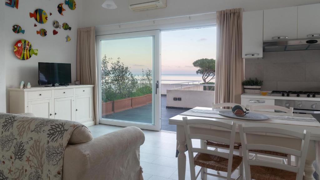 a kitchen with a table and a view of the ocean at La Casa Sul Mare in Cala Liberotto