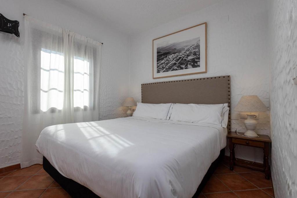 A bed or beds in a room at Tugasa Hotel y Apartamentos rurales La Posada