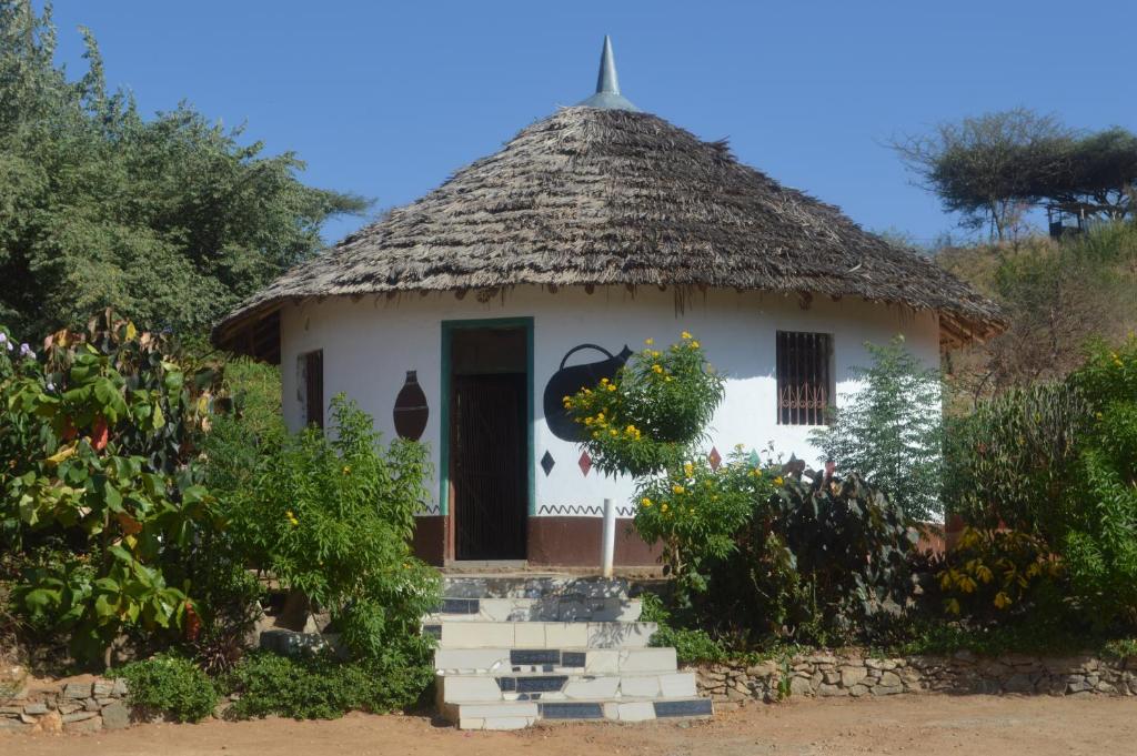 een klein huis met een rieten dak bij Holale Hotel in Moyale