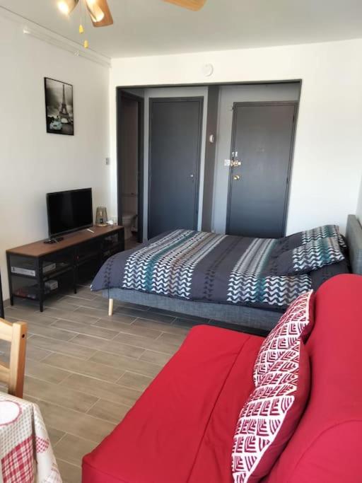 une chambre avec un lit, un bureau et une télévision dans l'établissement Studio chaleureux Caen, à Caen