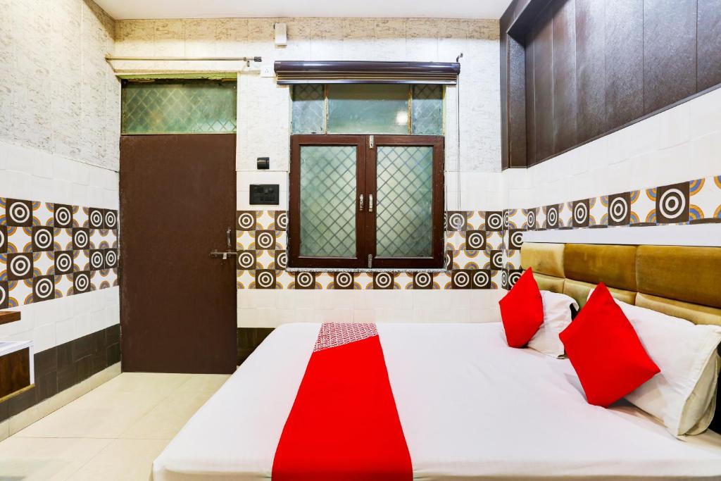 - une chambre avec un lit et des oreillers rouges dans l'établissement Royal Hotel, à Kanpur